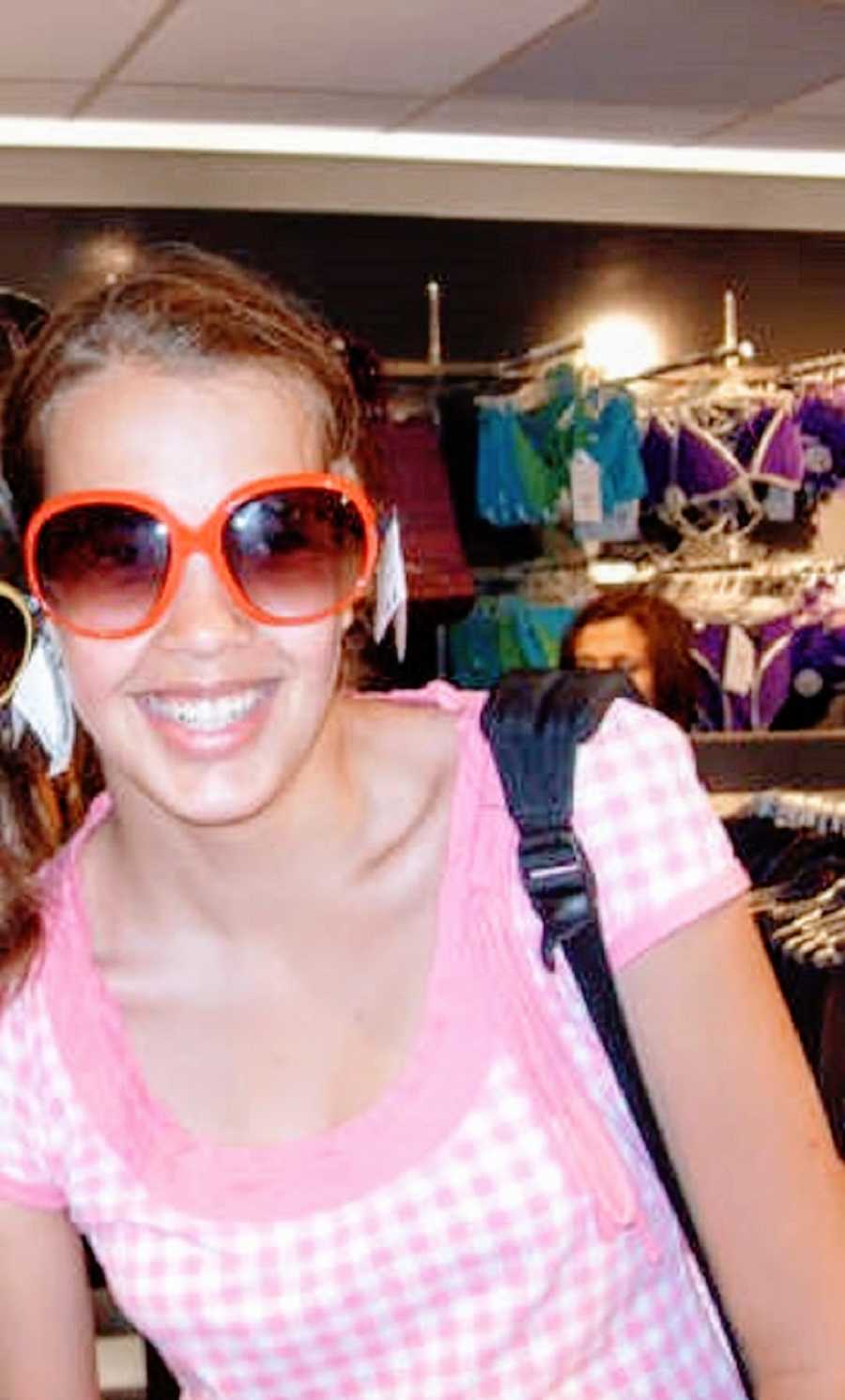 A person wearing a pink shirt and sunglasses