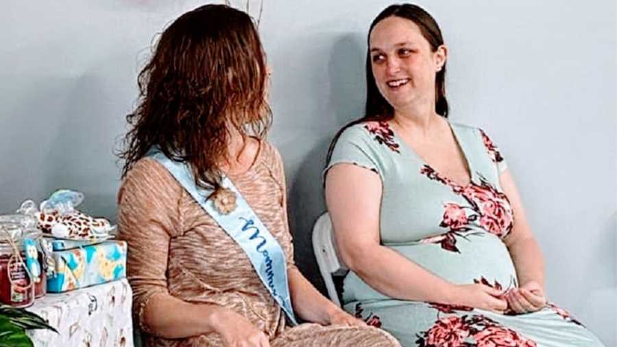A pair of women sit next to each other at a baby shower