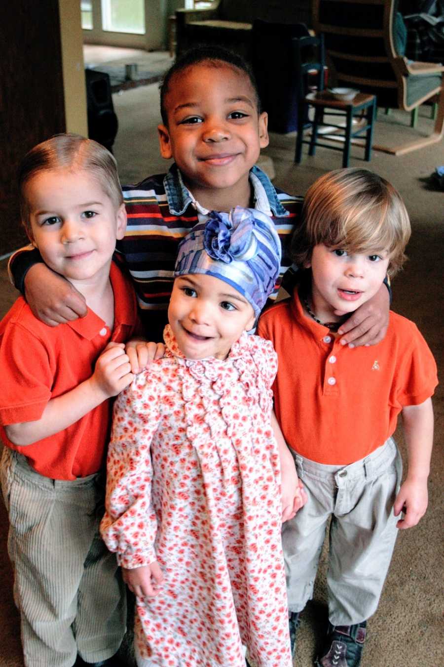 Three brothers stand with their little sister