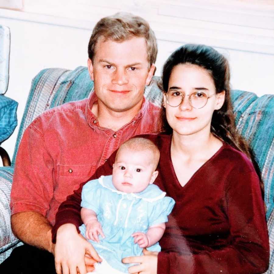 A husband and wife sit with their newborn daughter