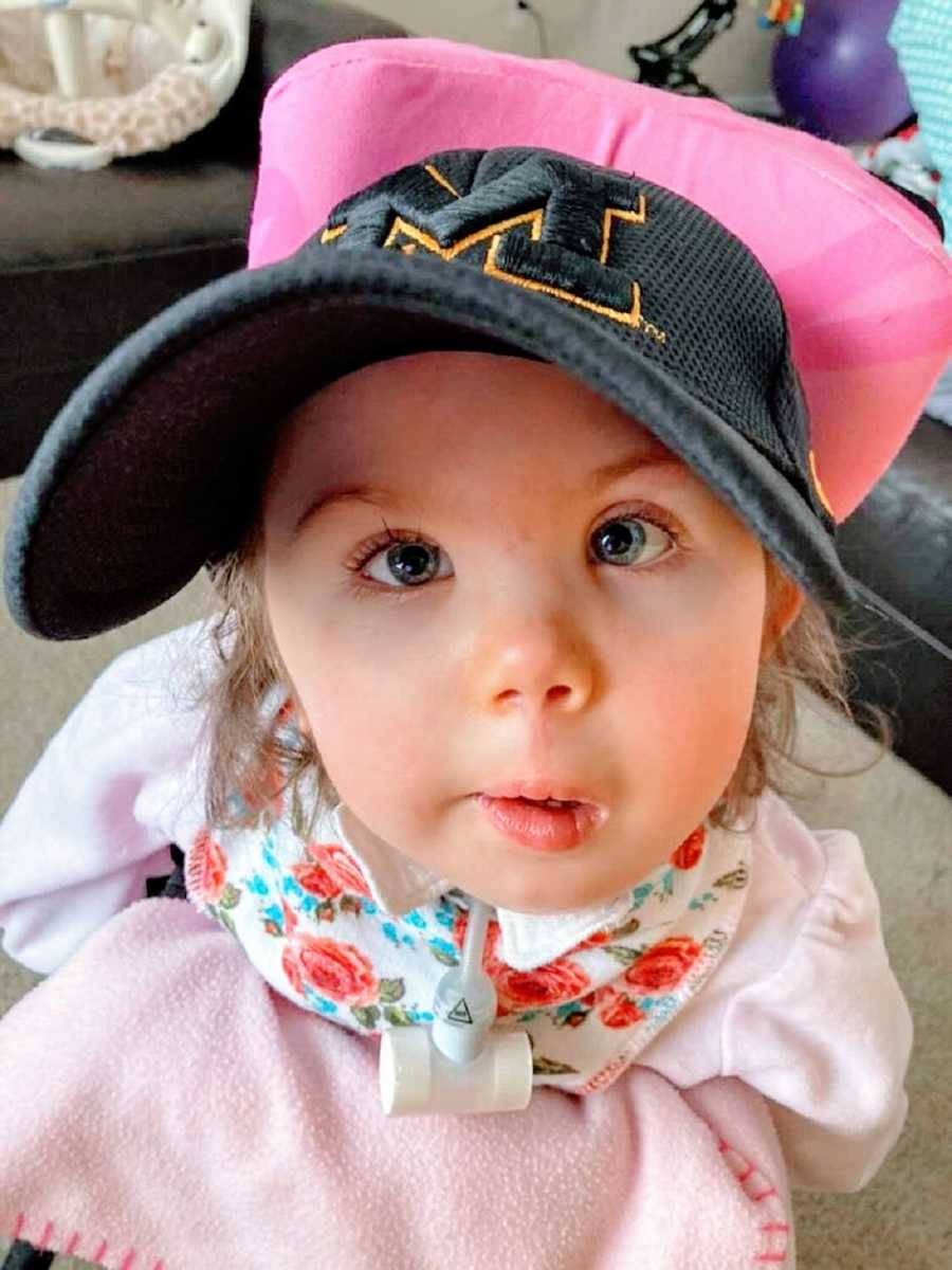 A little girl wearing a baseball cap