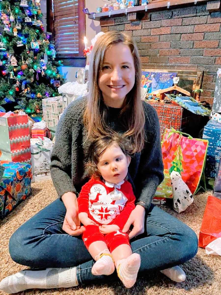 A mother sits with her baby girl on her lap