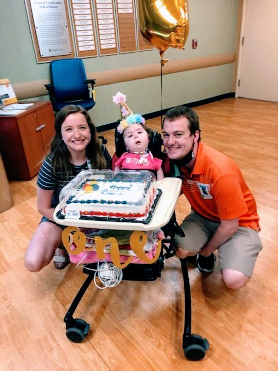 Parents sit with their baby girl in a hospital on her birthday