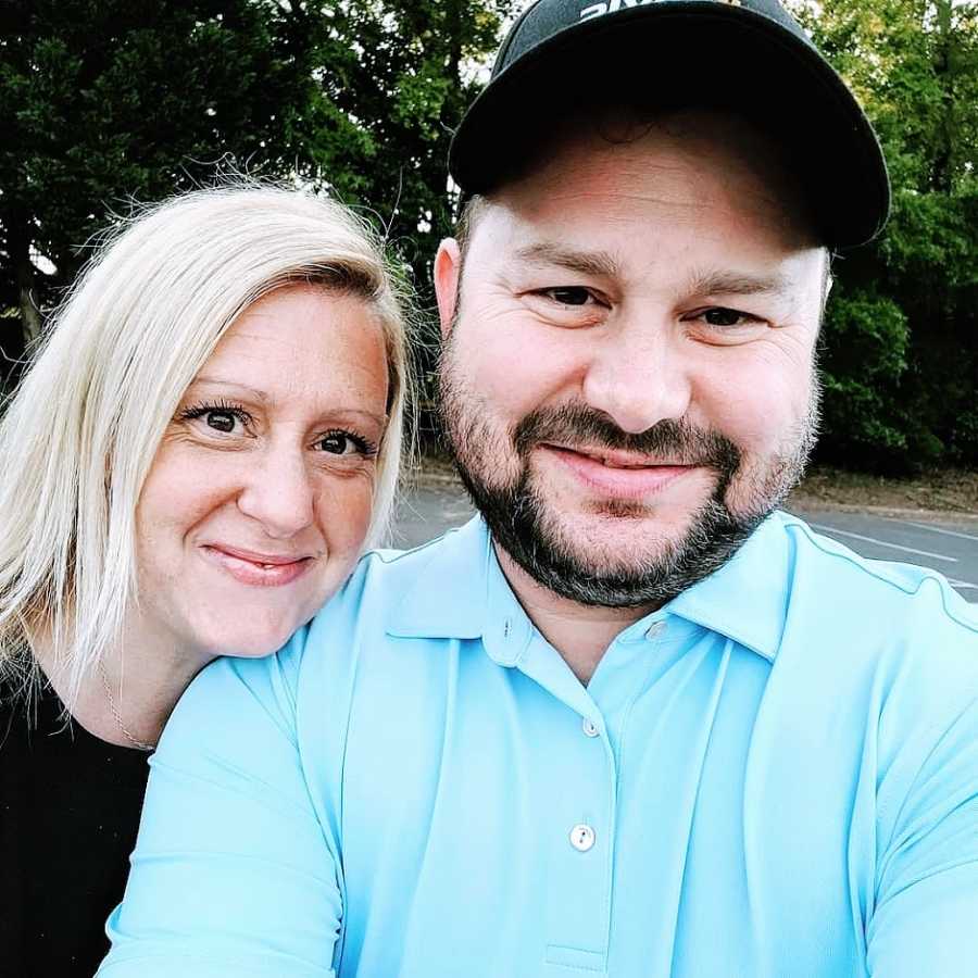 A woman leans her head on her husband's shoulder