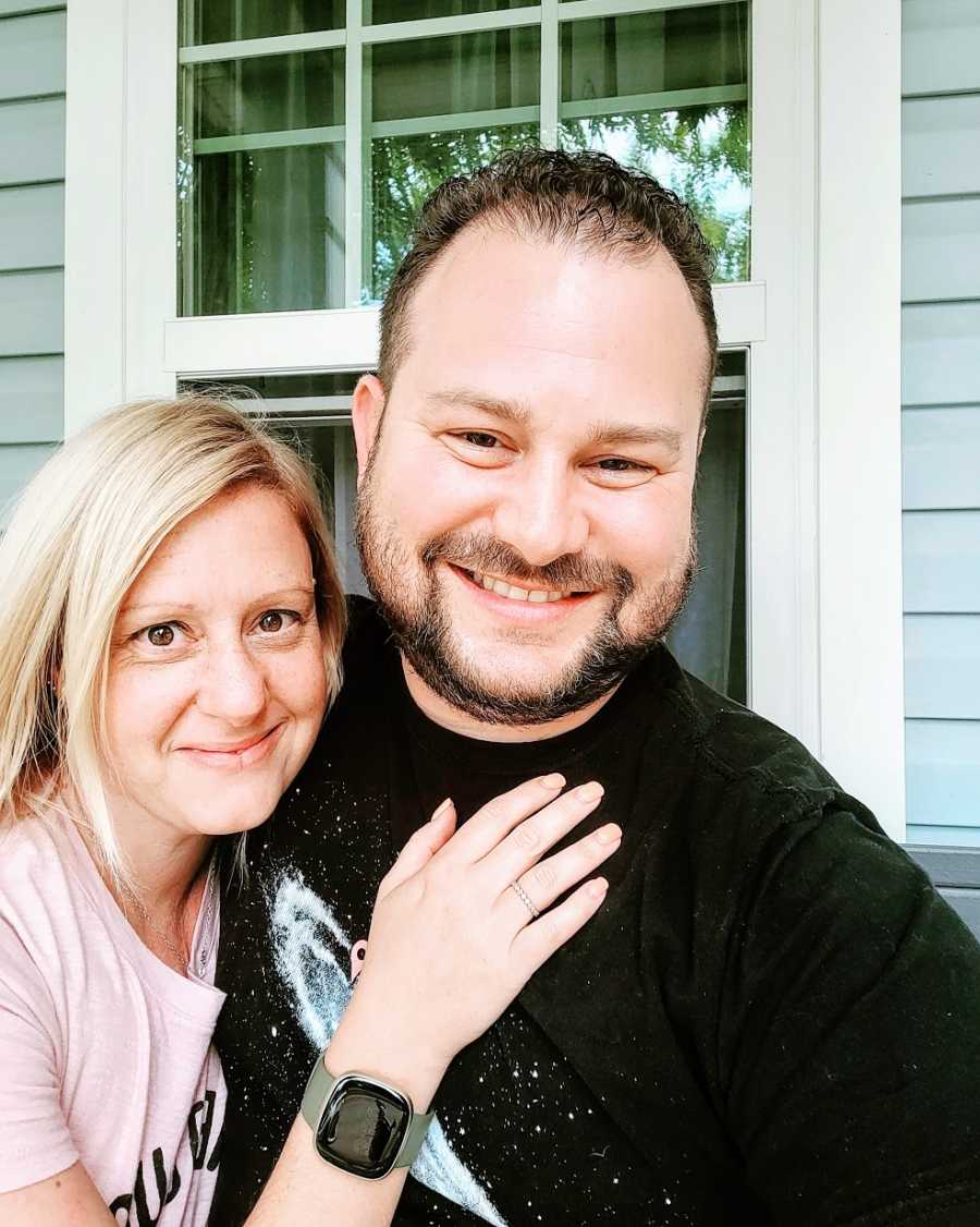 A woman and her husband together outside their house