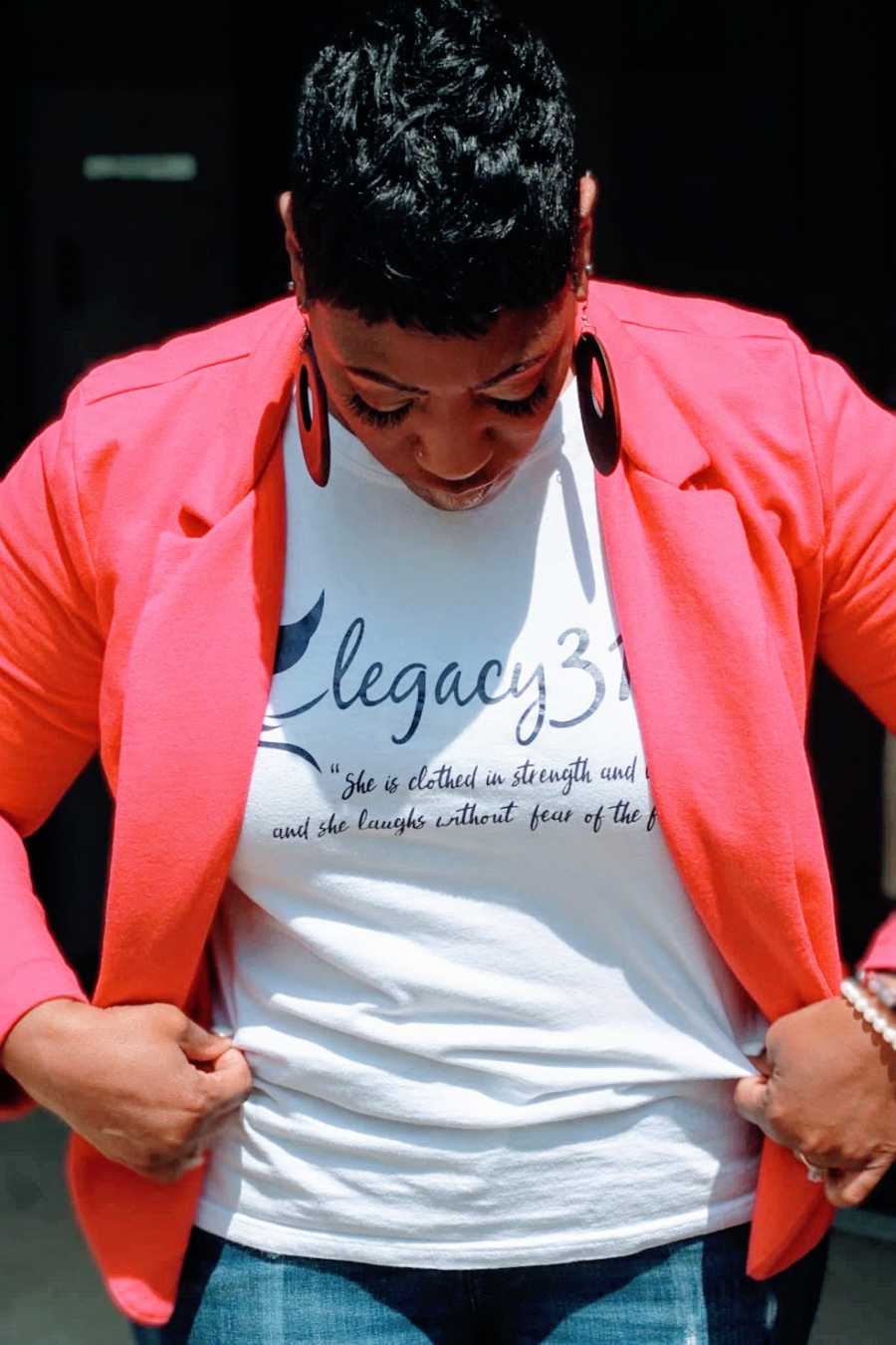 A woman wearing a pink blazer and large earrings