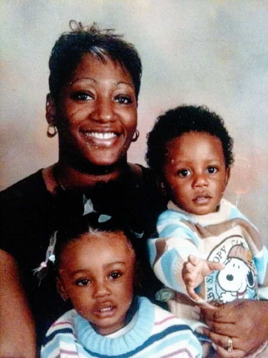 A mother sits with her two young children