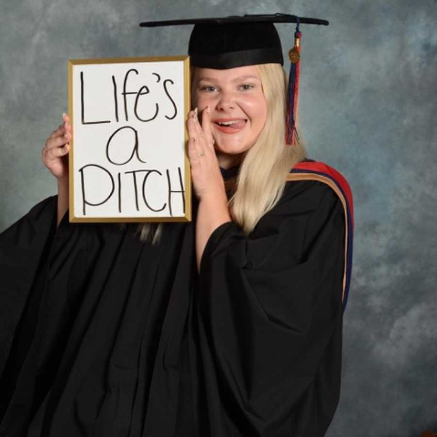 graduating high schooler holds up sign