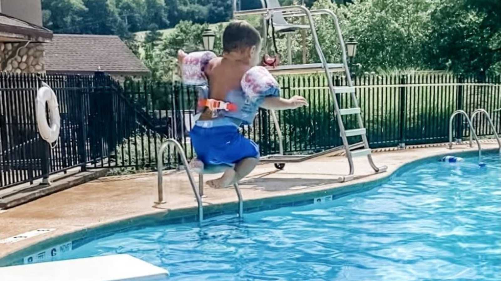 Mom snaps photo of adopted son jumping off the diving board at the local community pool