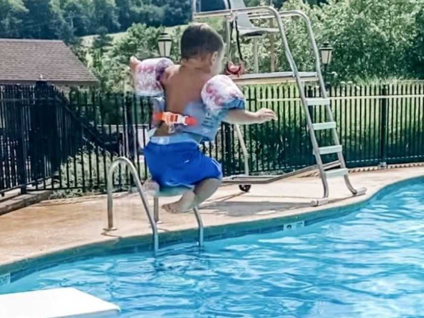 Mom snaps photo of adopted son jumping off the diving board at the local community pool