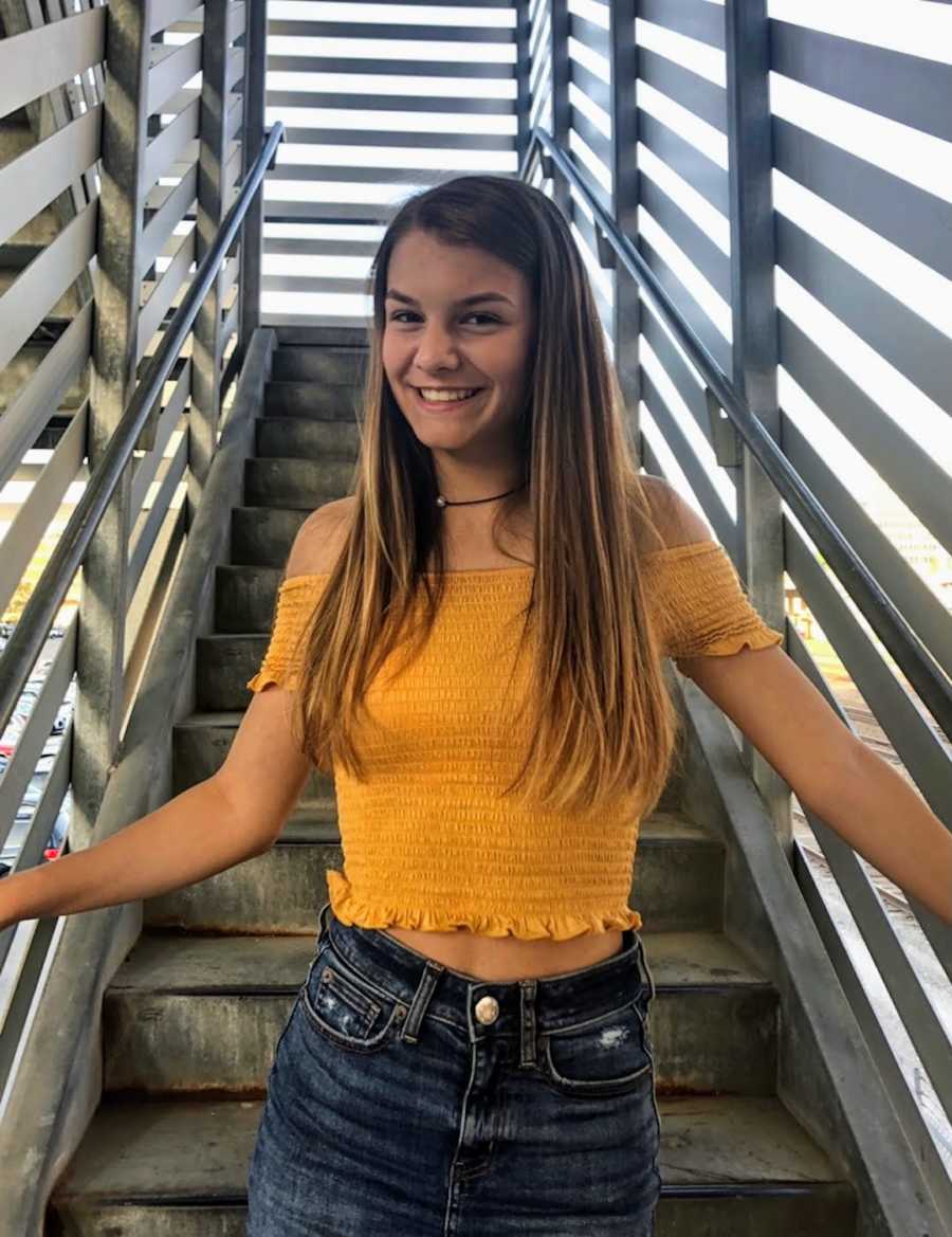 girl in an orange top smiling