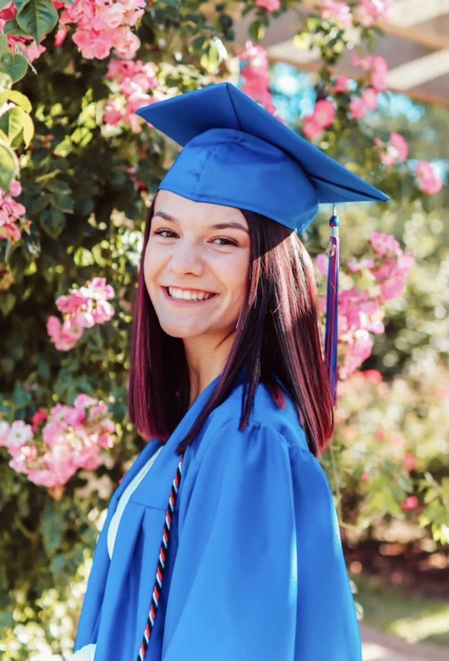 teenager in blue graduation cap and gown
