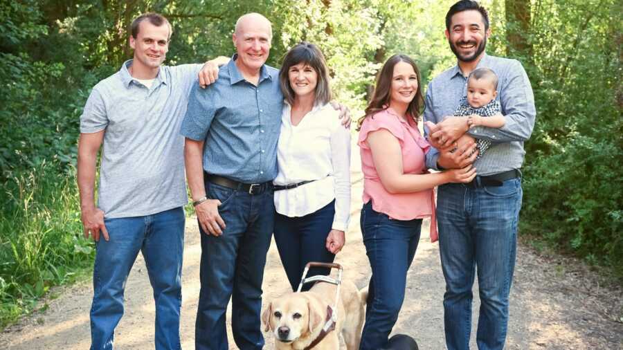 Family of three men and two women and a baby and dog