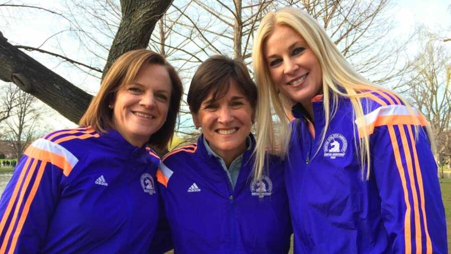 Three women in matching purple sweatshirts outside