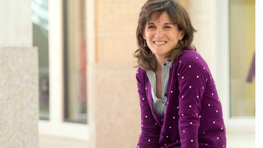 Woman in purple cardigan smiling 