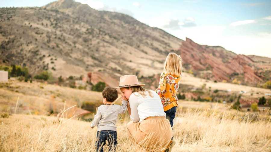 mom and two children in front of mountains