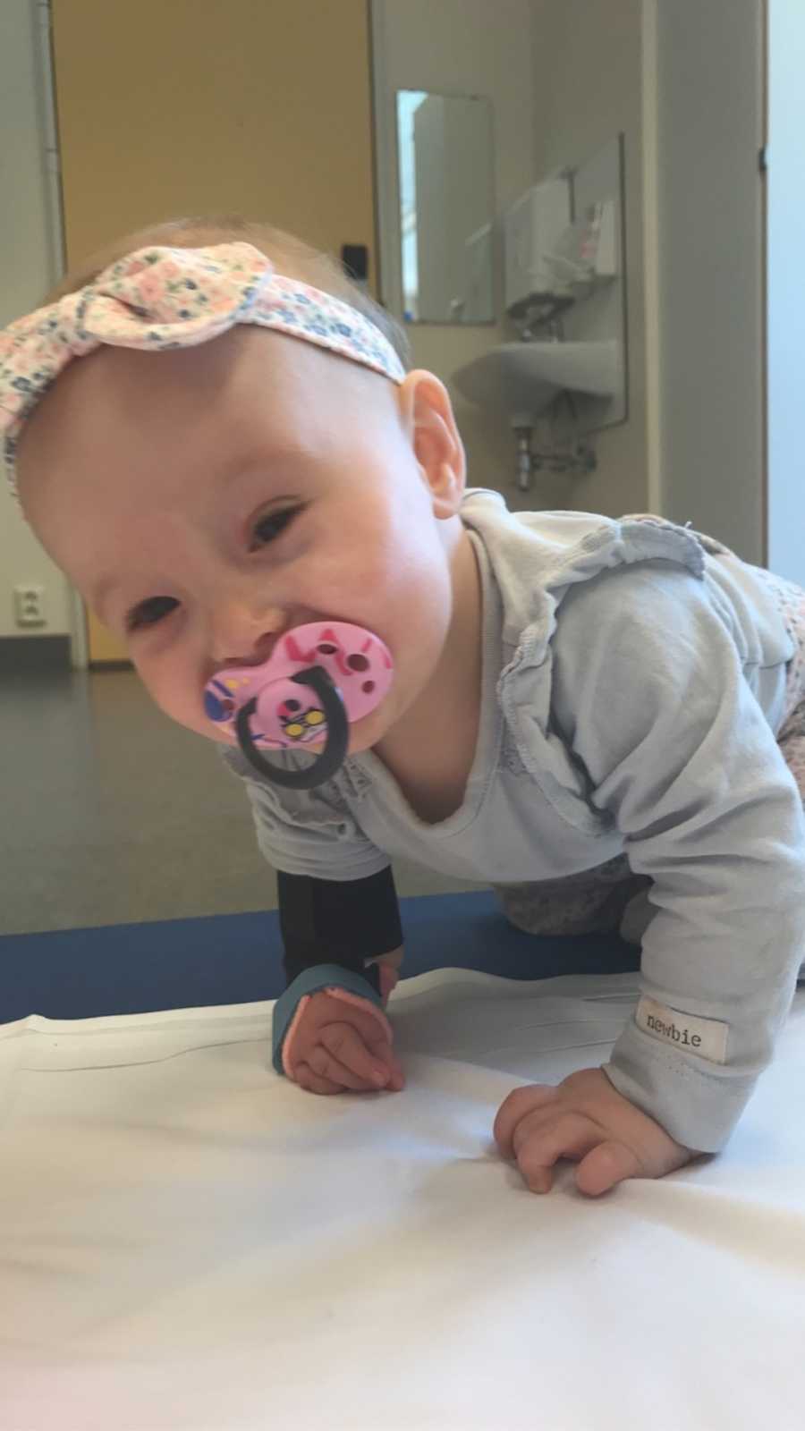 happy baby crawling with a pacifier