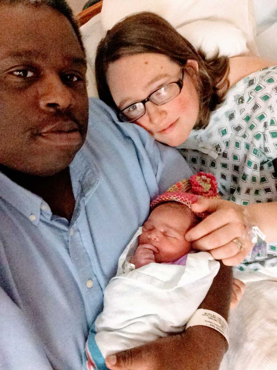 Couple who have experienced multiple miscarriages hold their newborn daughter together after the mom gave birth