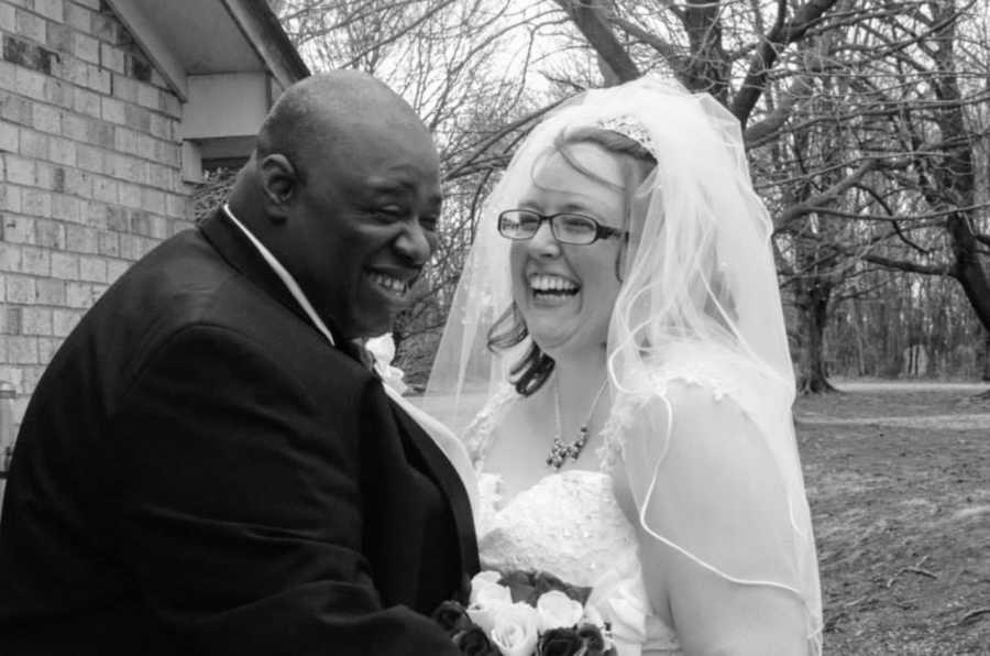 Newlyweds laugh together while taking wedding photos on their special day