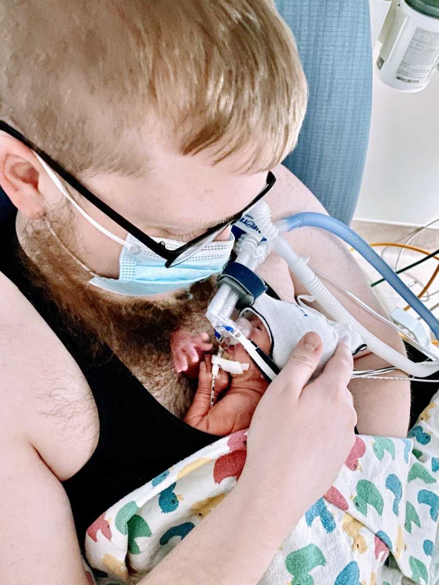 New young dad holds his rainbow baby born early at 30 weeks via emergency C-section