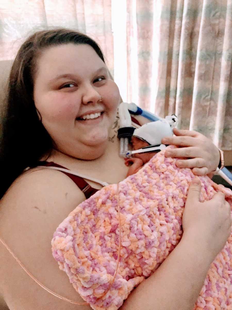 Woman holds her preemie rainbow baby after three miscarriages
