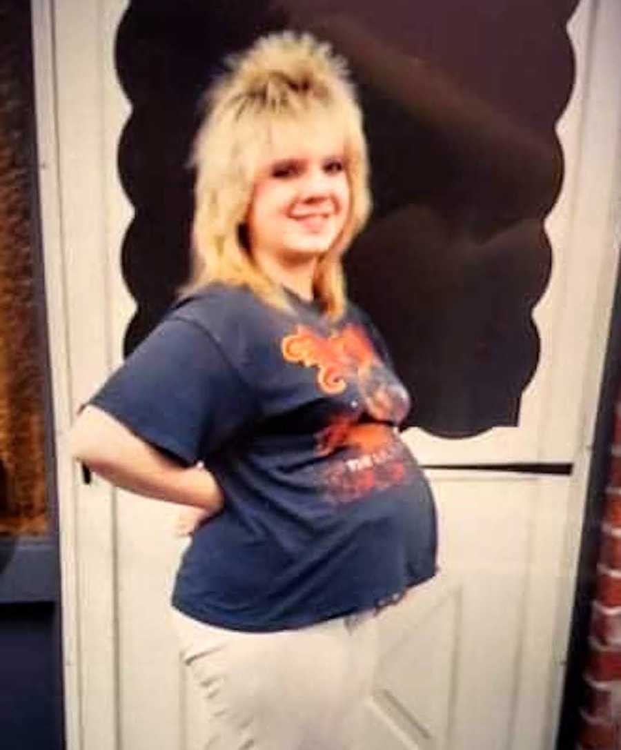 maternity photo of woman in front of a door