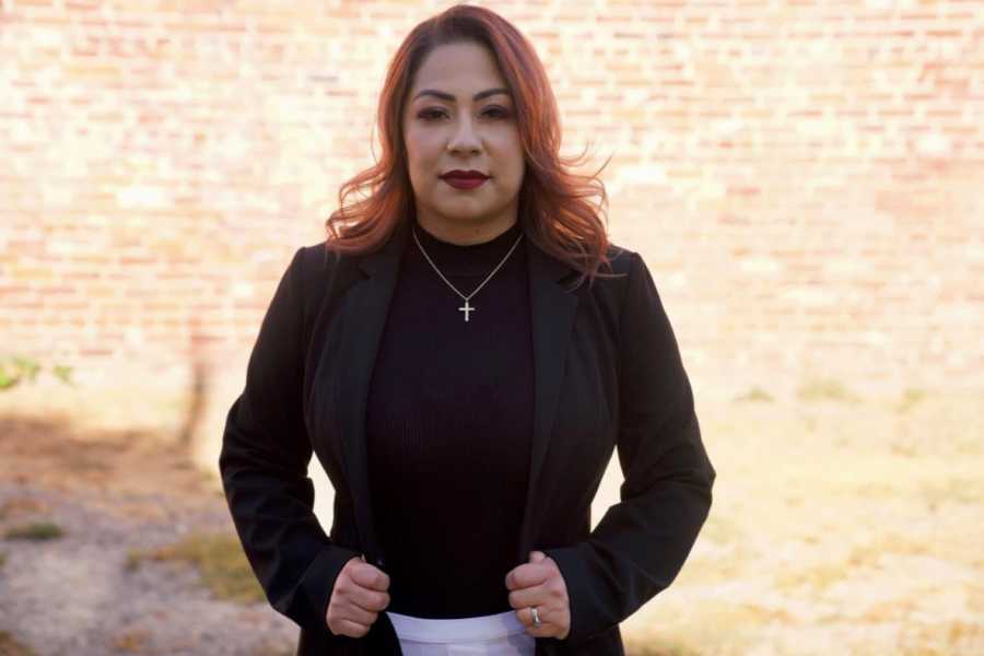 Woman who started her own nonprofit after surviving human trafficking stands tall and strong with a cross necklace on