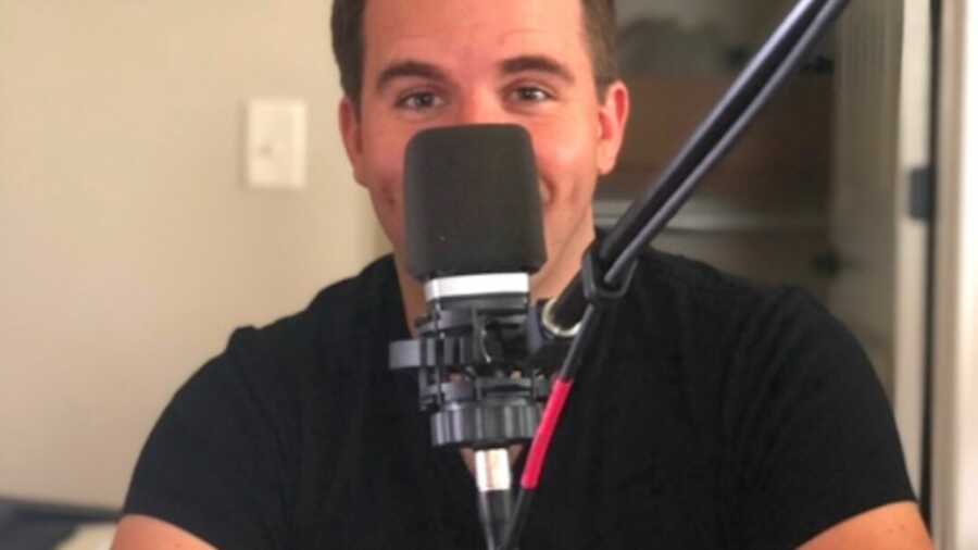 Man smiling behind microphone
