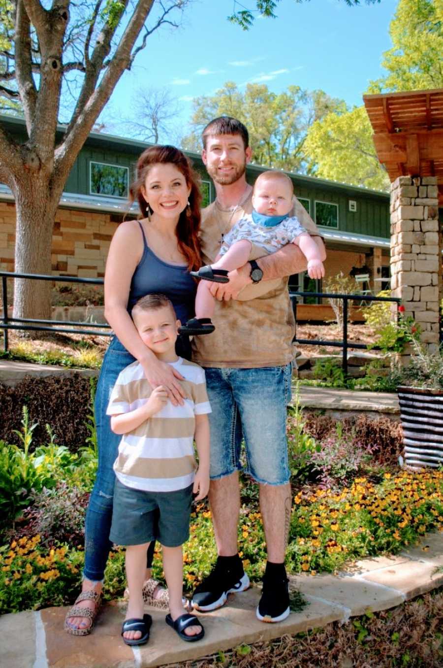 Blended family of four take a happy photo together in the warm sunshine