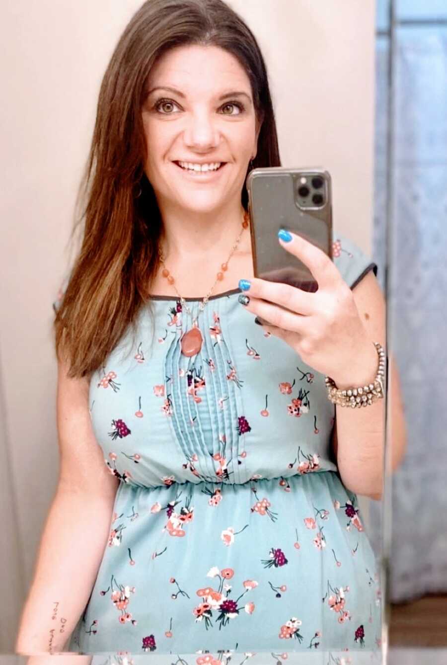 tired mom taking bathroom selfie in blue dress