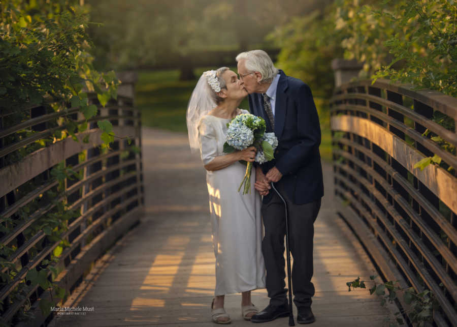 Couple celebrating their 50th wedding anniversary share a sweet kiss during a photoshoot celebrating their love