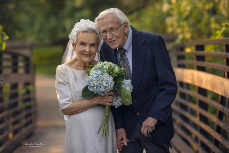 Elderly couple celebrating their 50th wedding anniversary wear their original wedding outfits during a photoshoot