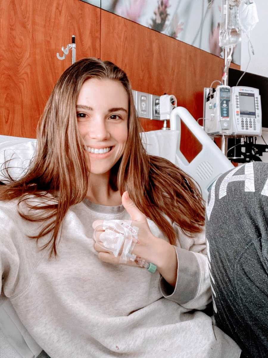 Woman battling ulcerative colitis takes a selfie in the hospital while attached to an IV, recovering from jpouch surgery