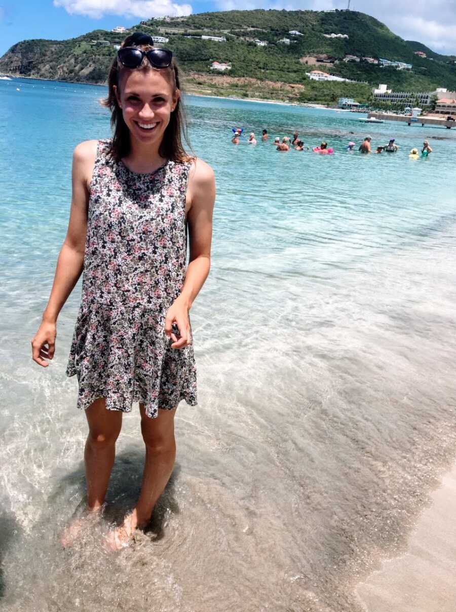 Young woman getting ready to go off to college enjoys a beach vacation in a floral dress