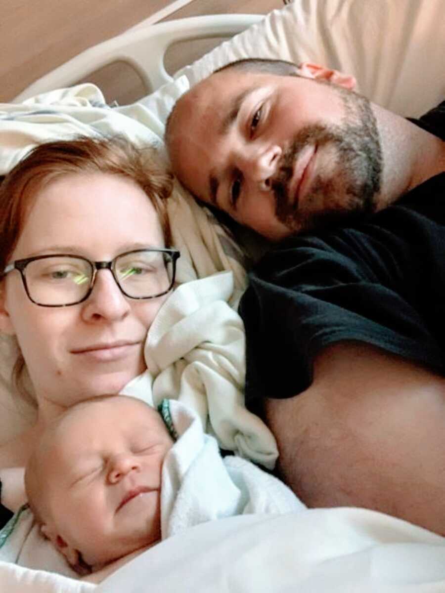 New parents cuddle with their newborn baby in the hospital after being diagnosed with hydrocephalus