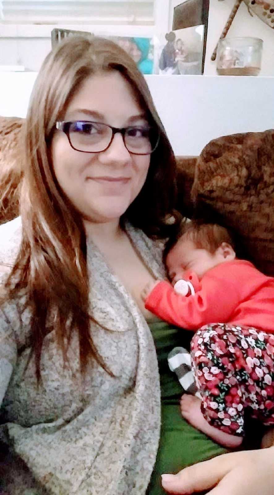 Girl mom takes selfie of her newborn daughter curled up sleeping on her chest