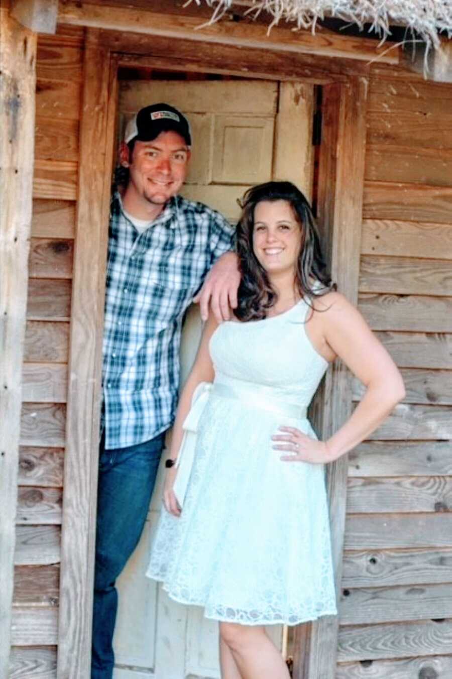 Recently married couple take photos together, the woman in a white dress and the man in a blue and green plaid shirt