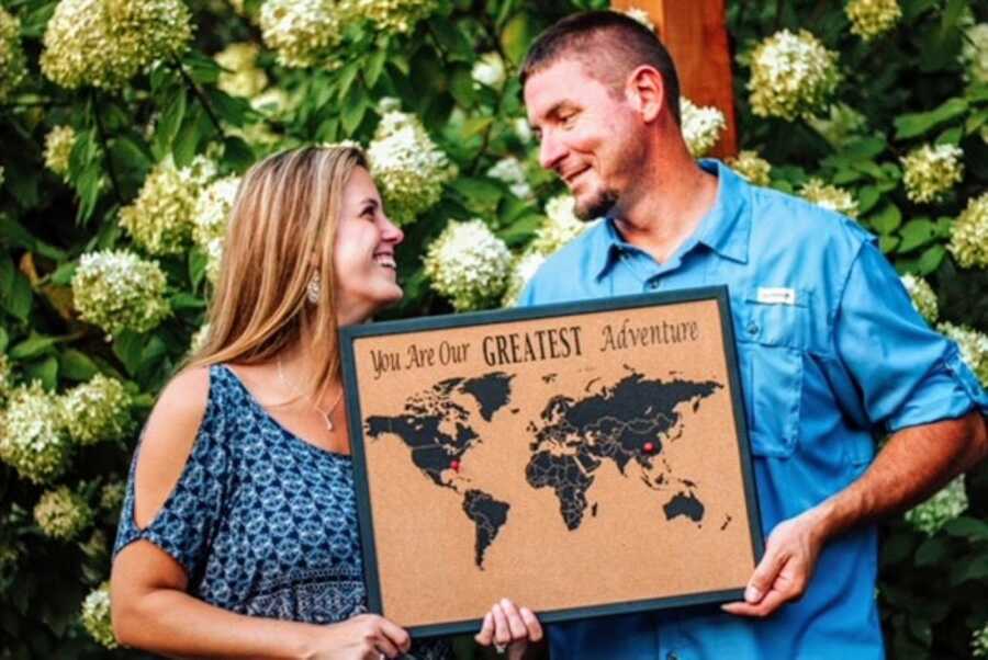 Couple announce they are adopting a son from China with a sign that reads "You are our greatest adventure"