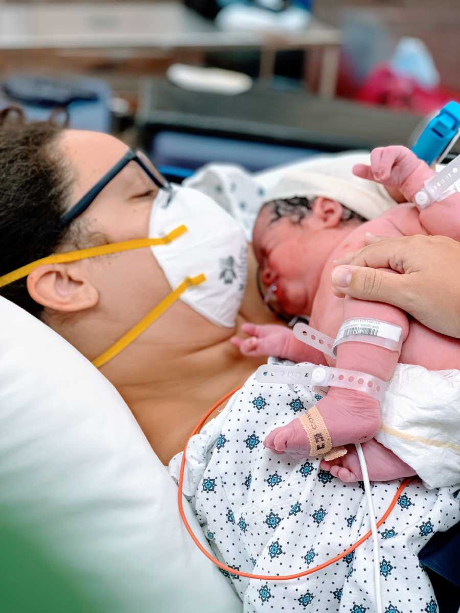 Mom holds her newborn son born with a limb difference before he goes to the NICU ward