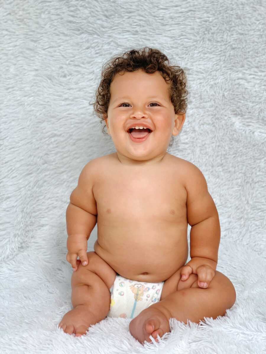 罕见的小男孩出生稀有肢体差异宽阔，在穿着芝麻街尿布的同时为相机微笑