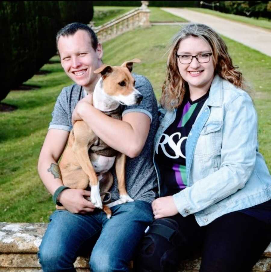 Woman with Woman with severe brittle asthma takes a family photo with her husband and their dog