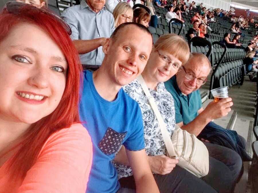 Woman with brittle asthma takes a selfie with her husband and his parents at a sporting event