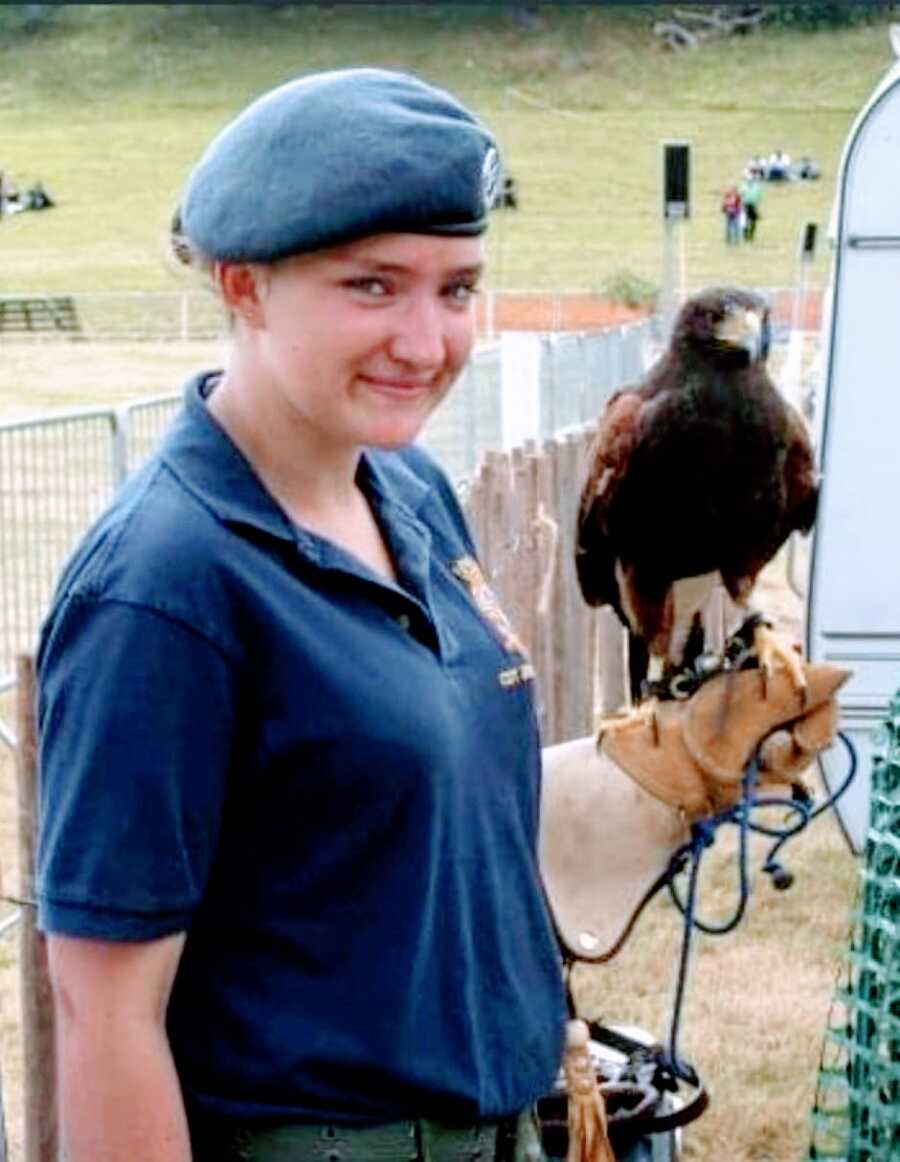 Young girl part of the Air Cadets holds a hawk while in uniform