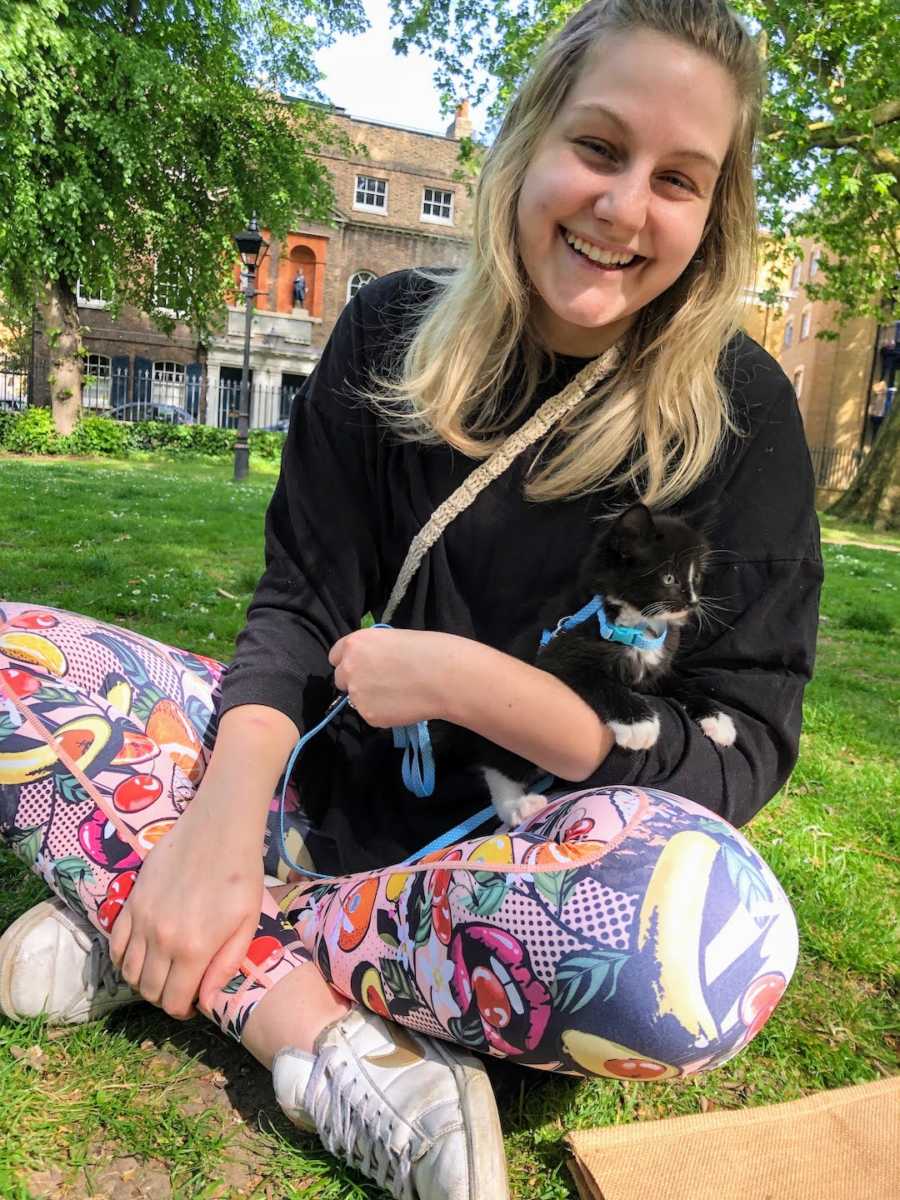 woman sitting on the grass with her cat