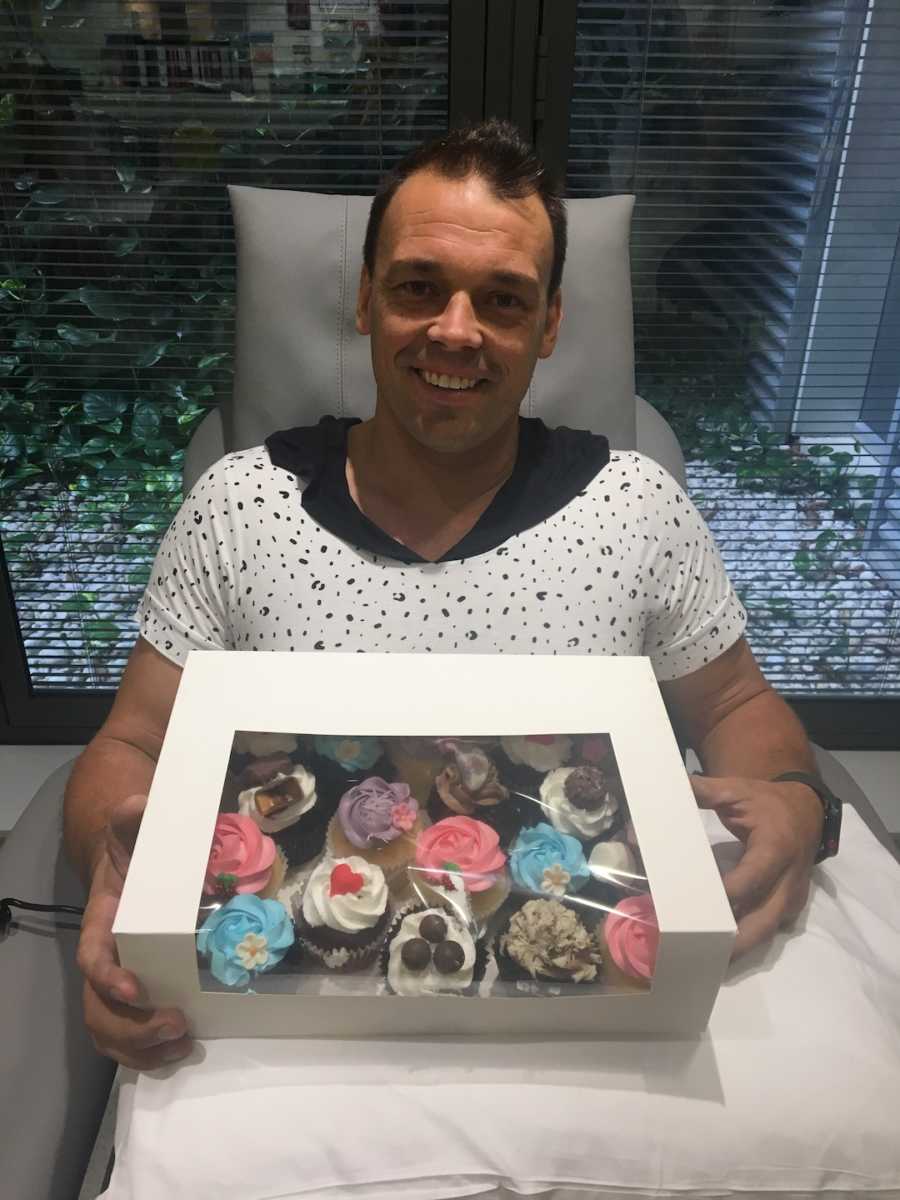 dad holding box of cupcakes