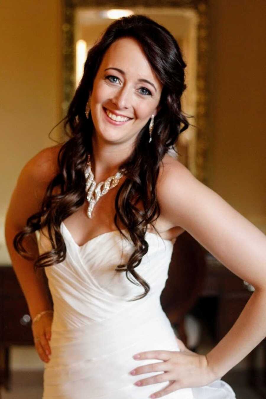 Young woman smiles big in her wedding dress before the wedding ceremony