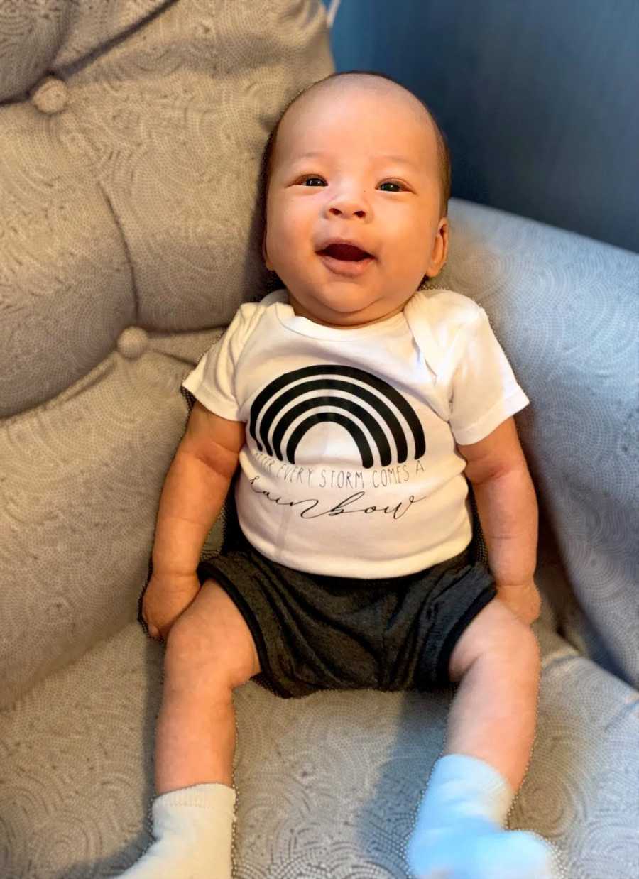 baby smiling in a rainbow shirt