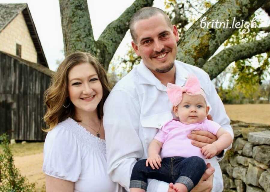 Married high school sweethearts take a photo with their newborn baby girl 