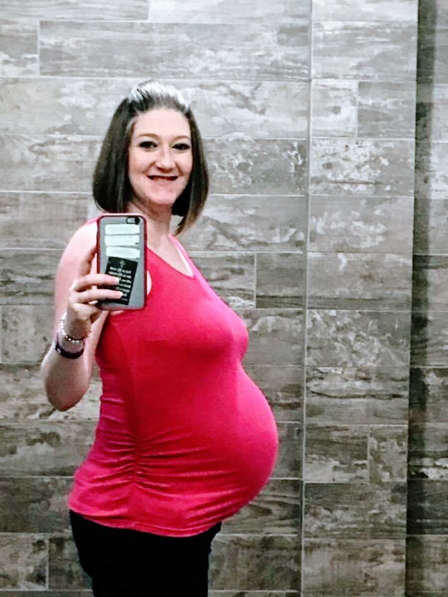 Woman battling lupus takes a mirror selfie, showing off her baby bump