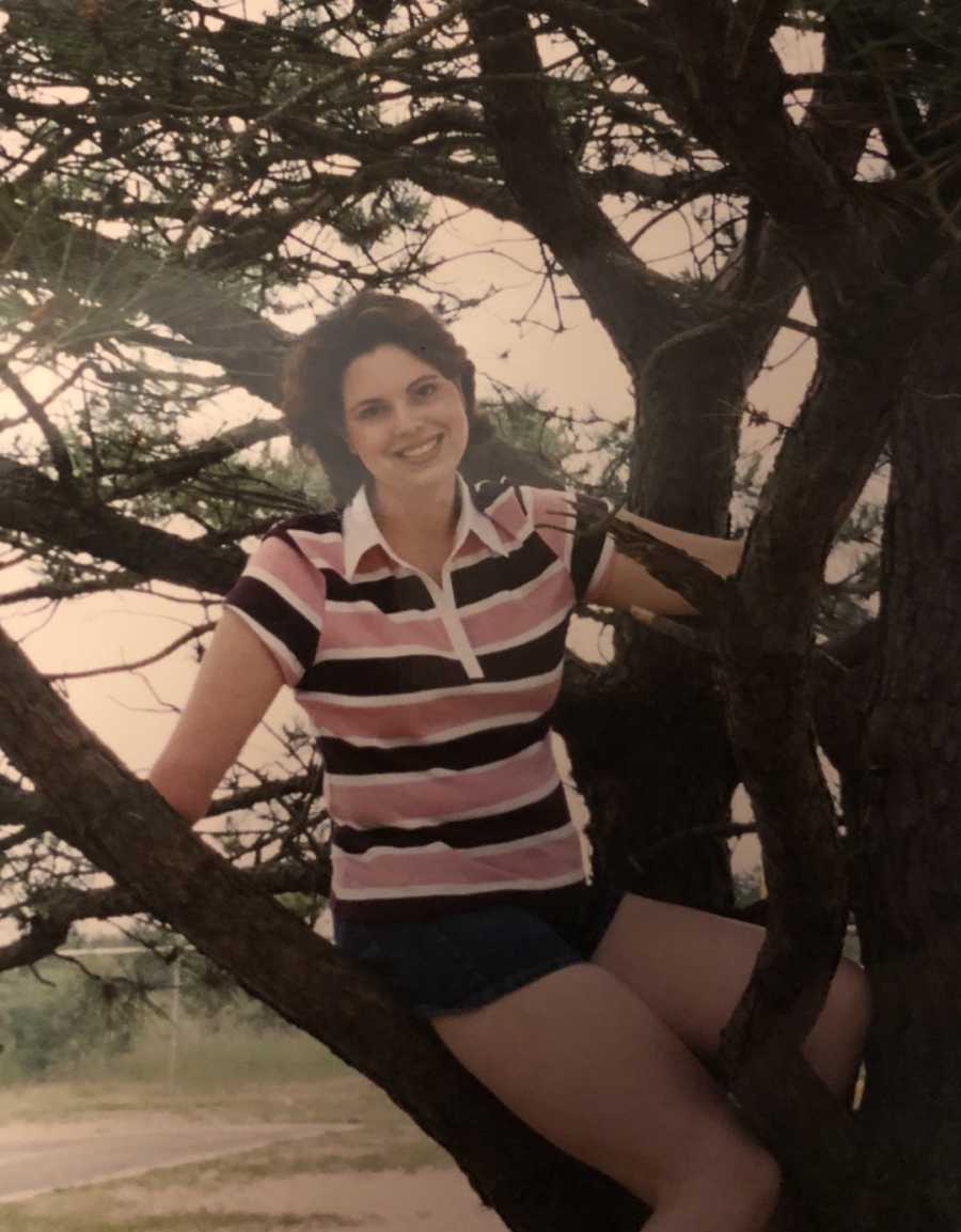 woman with one arm in a tree